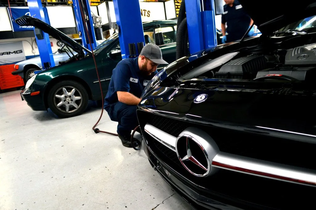 Technician mounting a tire on a Mercedes-Benz wheel at S & S Mercedes in Sarasota